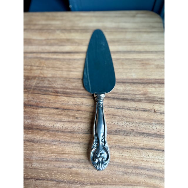 A cake or pie server with a sterling silver hollow handle and a stainless steel blade. The handle is cast in a Victorian...