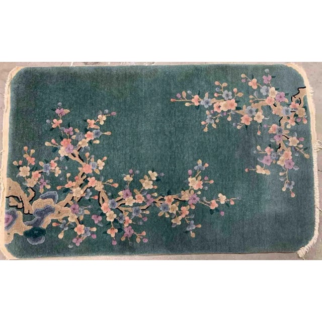 Handmade antique Art Deco Chinese rug in green shade with floral design. The rug is from the beginning of 20th century in...