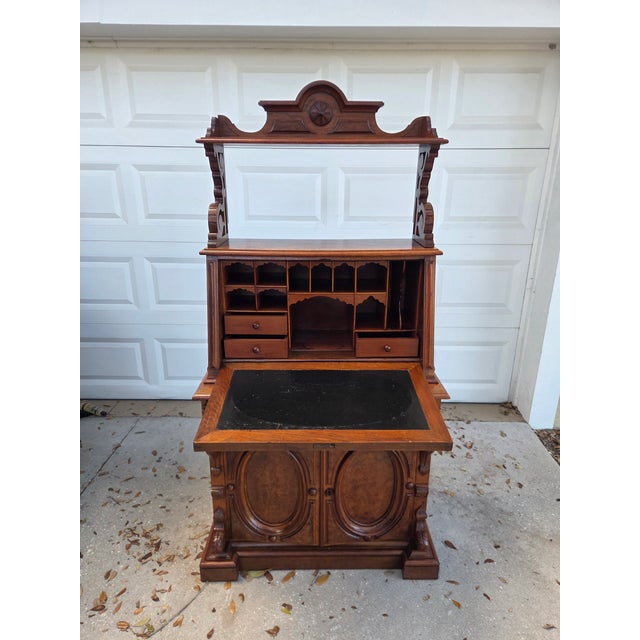 A commanding late 19th to early 20th century secretary desk that embodies the richness of Victorian craftsmanship. The...