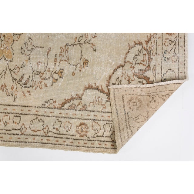 This is a vintage Turkish Oushak rug from the Mid 20th Century. The piece was hand-knotted.