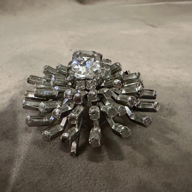 This striking 1940s Italian brooch beautifully blends the streamlined glamour of Art Deco design with the bold, often...