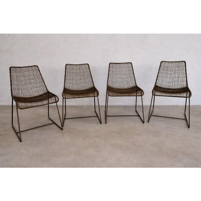 Set of four Sonoma chairs featuring finely woven wire mesh seats and backs paired with minimalist sled-style iron bases....