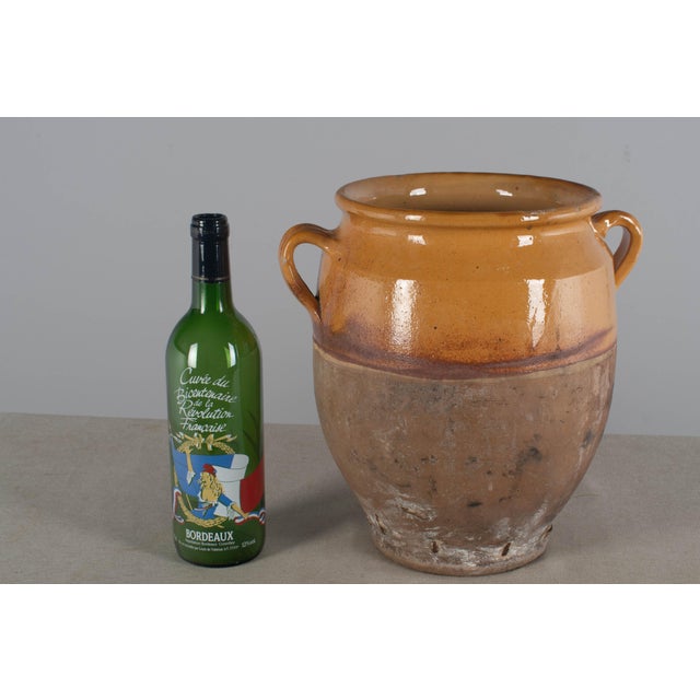 A late 19th century earthenware confit pot from the Southwest of France with traditional yellow ochre glaze. Chips and...