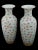A pair of antique Chinese Famille Rose porcelain vases. Each vase has an urn shaped body with a fluted mouth. The...