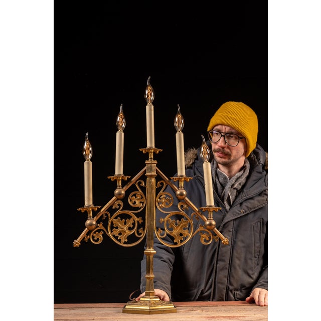 Cast metal five-light candelabra table lamp executed in a Gothic Revival idiom, with symmetrical scrolling arms, foliate...