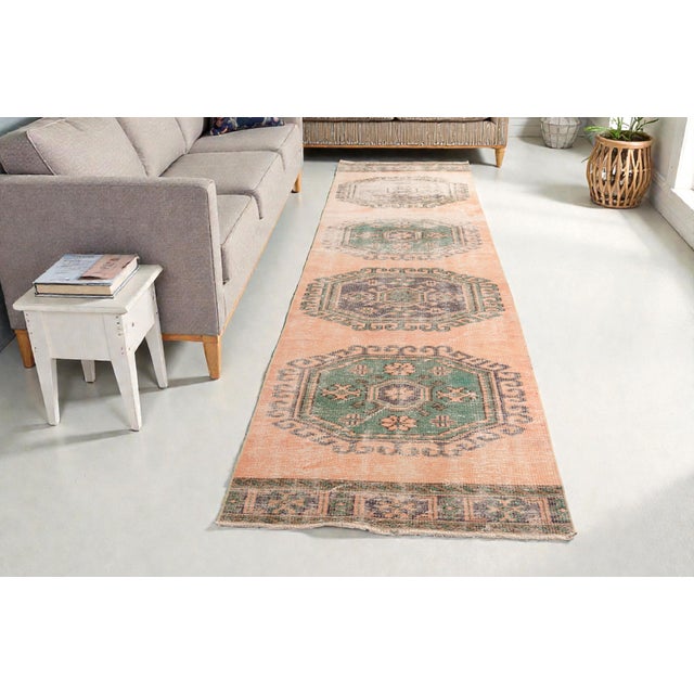 This is a vintage Turkish Oushak rug from the Mid 20th Century. The piece was hand-knotted.