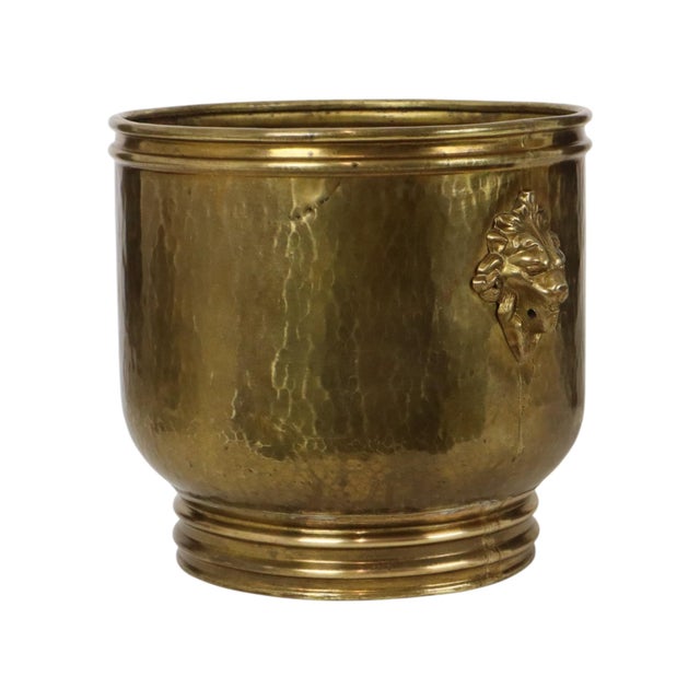 Large antique jardinière, flower pot, or cache-pot made of hammered brass, featuring lion-head handles; dating from the...