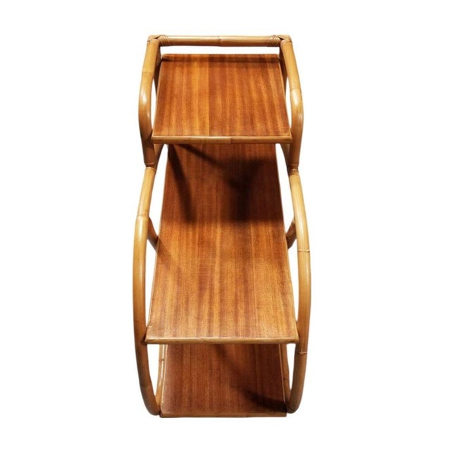 This beautifully restored Mid-century rattan side table features 3-tier table tops with 1 strand 3/4 pretzel rattan sides...