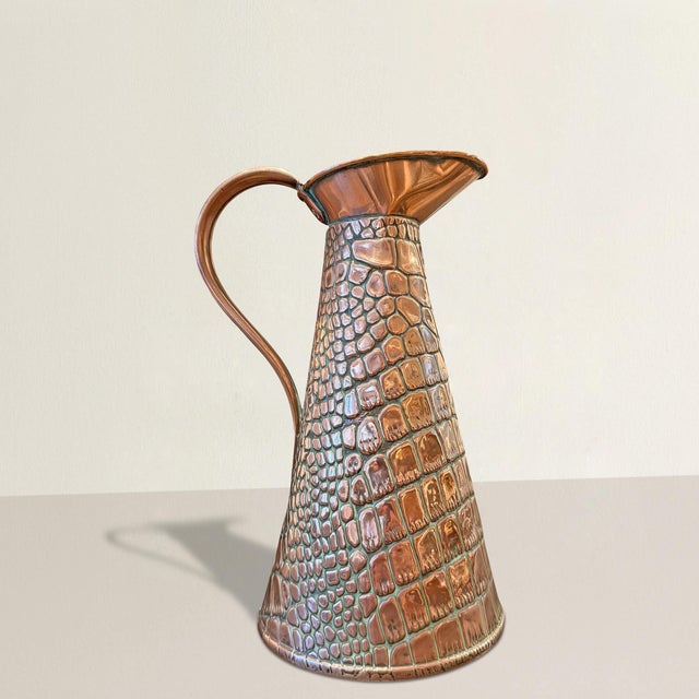 This early 20th-century English Arts & Crafts copper vessel leans closer to object than accessory—its surface relentlessly...