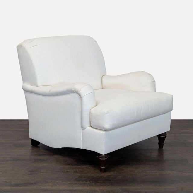 This Pottery Barn lounge chair offers a simple and elegant design with soft white upholstery and classic wooden legs. The...