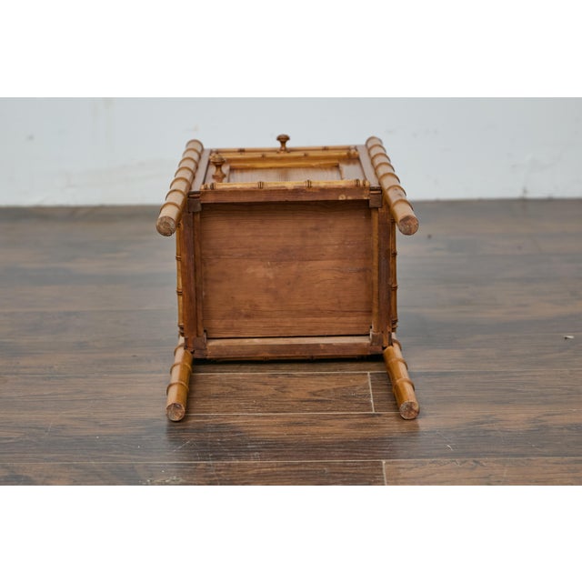 An English pine faux bamboo bedside cabinet from the 19th century with white marble top. Crafted in 19th-century England,...