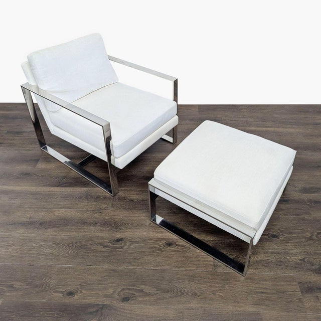 This sleek lounge chair and ottoman set from Restoration Hardware features a sturdy polished metal frame and white...