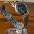 Vintage Smiths Empire Shockproof 5 Jewels mechanical wristwatch featuring a handsome black textured dial with gold-tone...