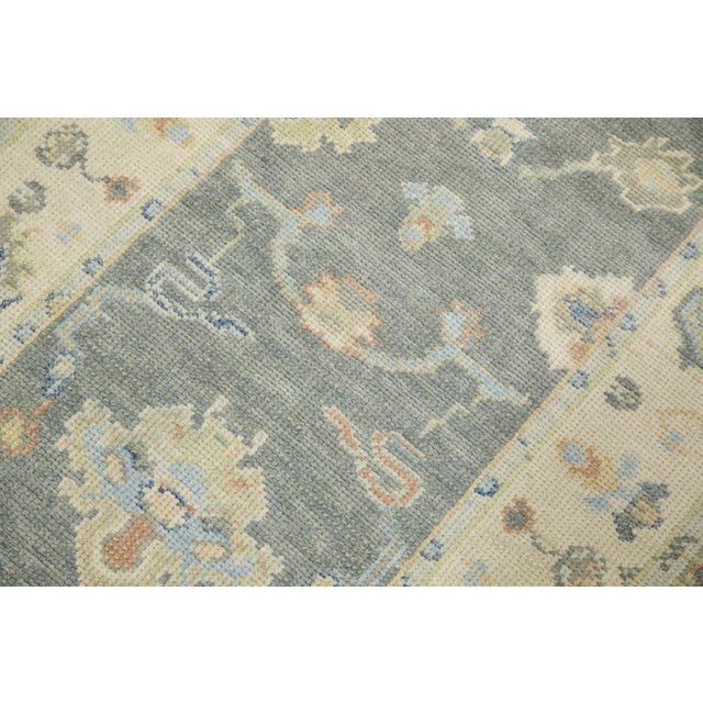 This modern Turkish Oushak rug is a stunning piece of art that has been handwoven using traditional techniques by skilled...