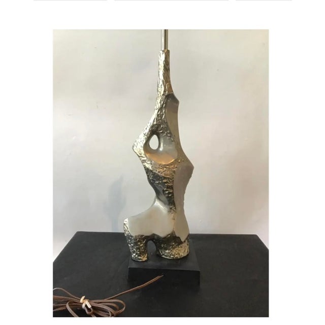 A pair pf Brulalist chrome lamps by Raymond Barr for Laurel Lamps. The lamps are designed to resemble an abstract sitting...