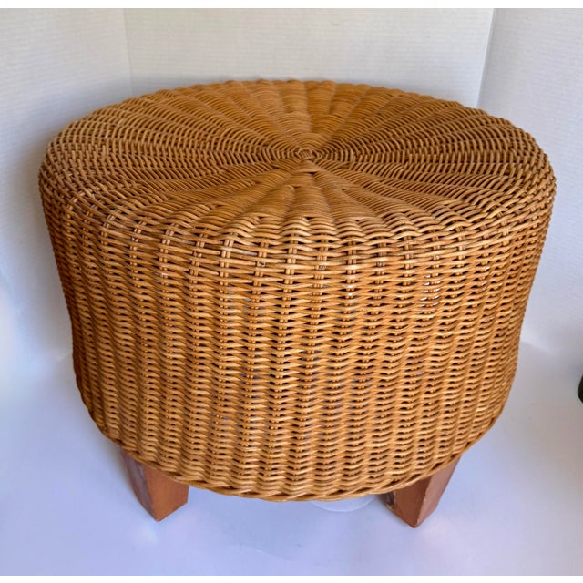 This vintage round wicker ottoman dates to approximately the 1970s–1980s and features a beautifully woven rattan body...