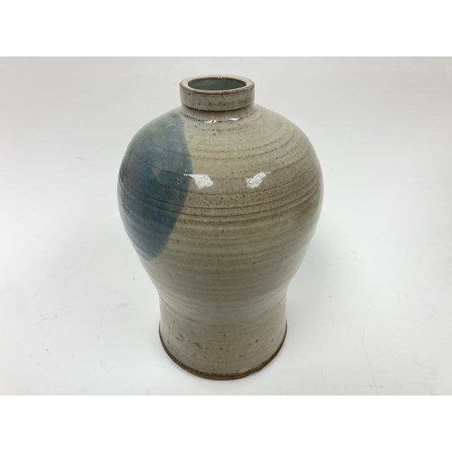 A well crafted Pottery Vase in bottle form in Asian style. The Vase with a natural lightly ribbed body and narrow neck...