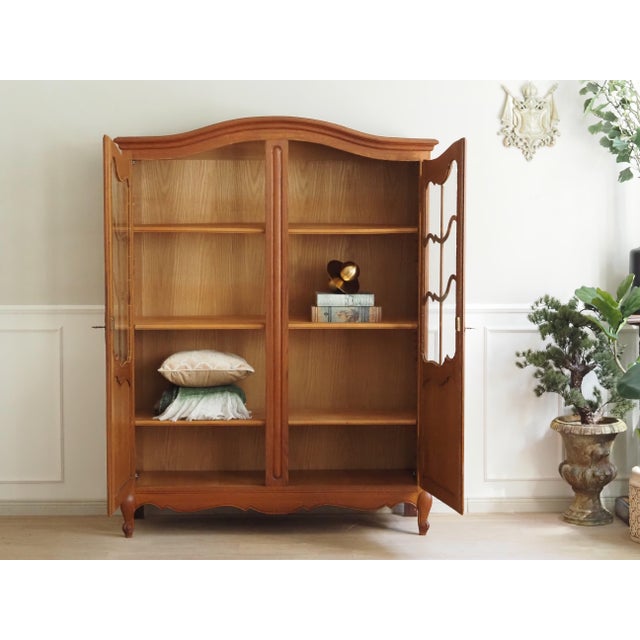 An oak display cabinet, a high-quality replica of historical furniture inspired by 18th-century French designs. The design...