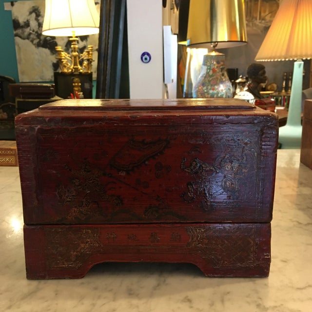 Vintage wood Asian box with patinated red lacquer and designs on the top, front and sides. The top is large and the bottom...