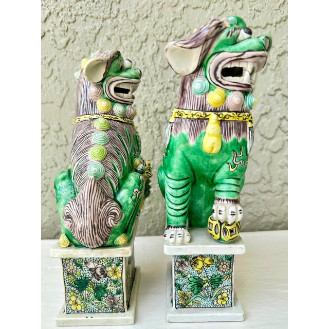 Antique Famille Verte porcelain foo dogs/guardian lions. This pair consists of a male and female lion on rectangular...