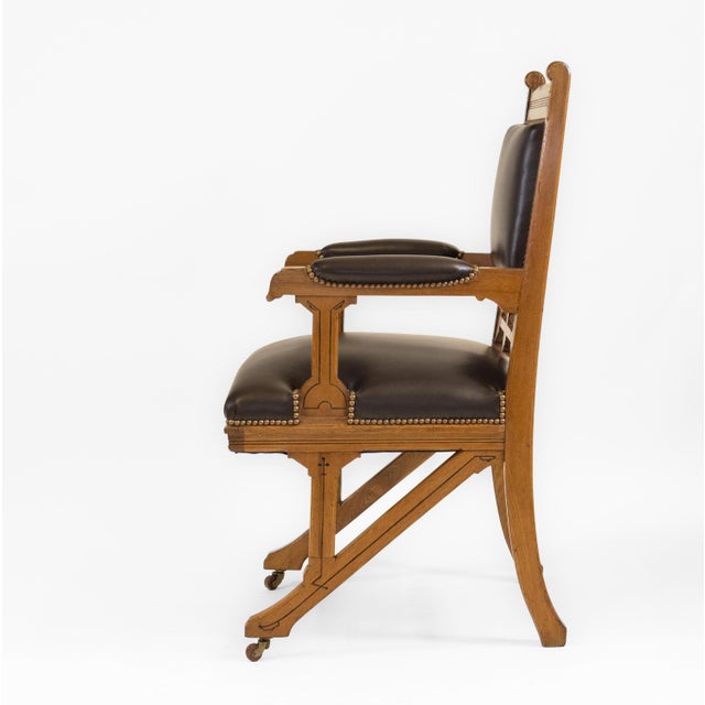 Antique Gothic Revival ash & leather armchair desk chair, sitting on castors. English - Circa 1880. The chair has been...