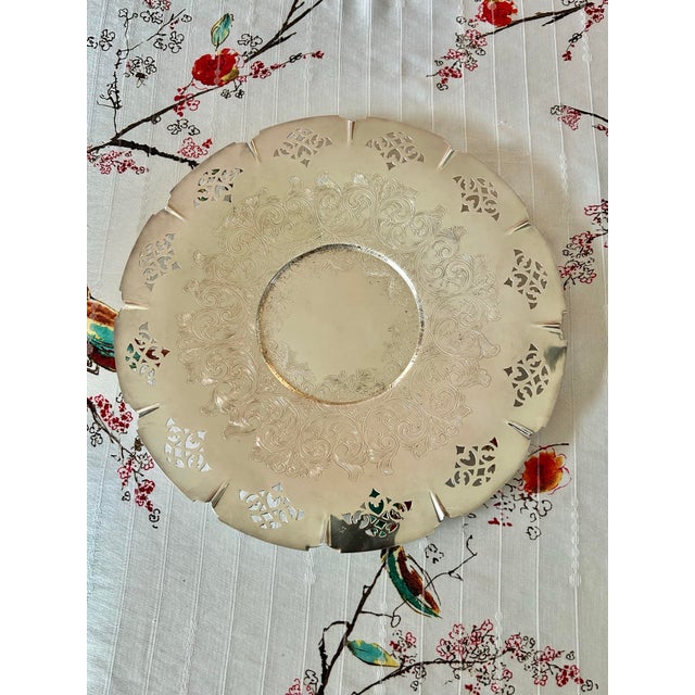 This silver plate round tray is 12.5”w and is reminiscent of serving wedding cake in days gone by. The edge is pierced...