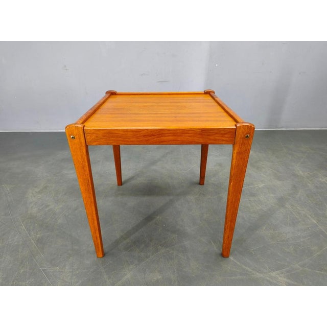 Authentic 1960s danish mid century side table crafted from teak wood with teak veneer top. The table features a minimalist...