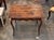 Rectangular French side table with a plank top showing pronounced surface wear and patina from use. The apron is scalloped...