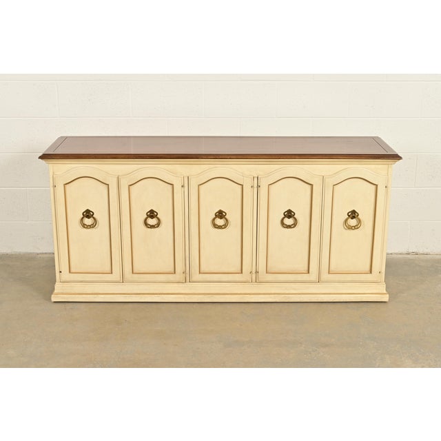 A gorgeous French Provincial Louis XV style sideboard, bar cabinet, or credenza By Drexel USA, Circa 1960s Cream lacquered...