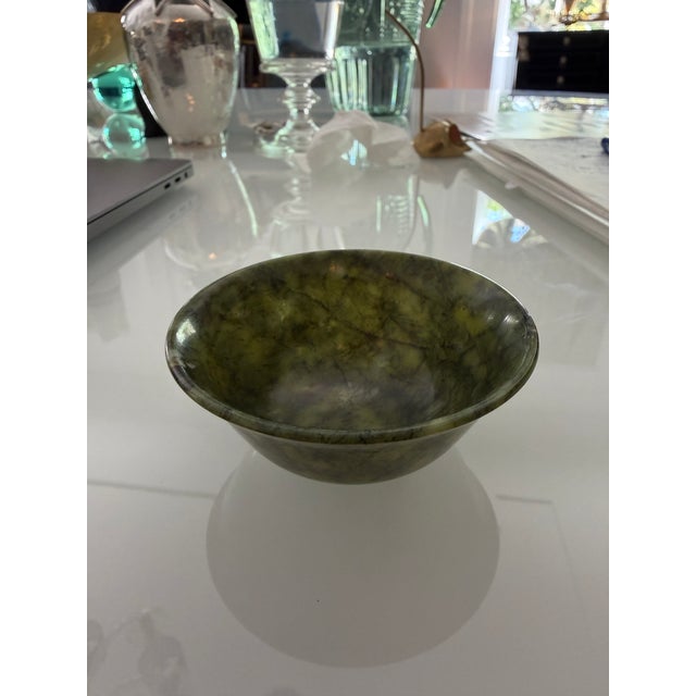 A striking hand-carved bowl crafted from spinach jade with deep "mossy" green hues and dark branch-like veining typical of...