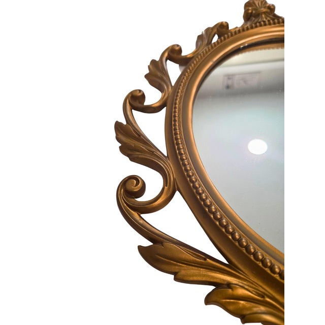 This vintage Syroco mirror is a beautifully detailed decorative piece that embodies the opulence of Hollywood Regency...
