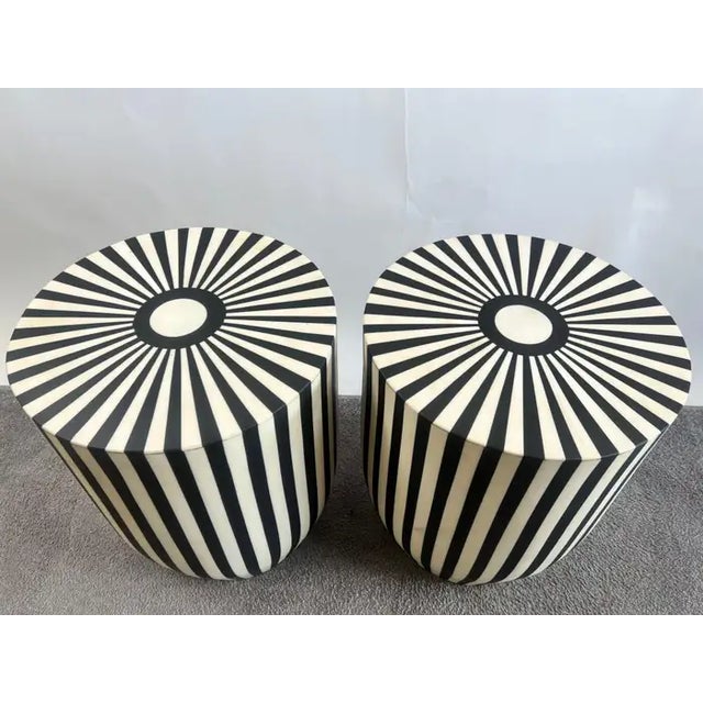 A one of kind pair of Art Deco style black and white side tables or stools featuring a striped design. The tables are made...