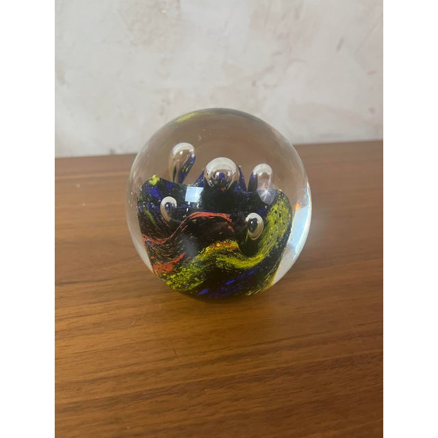 Sulfide/paperweight in clear, spherical blown glass. This piece features a dynamic internal inclusion with bursts of vivid...