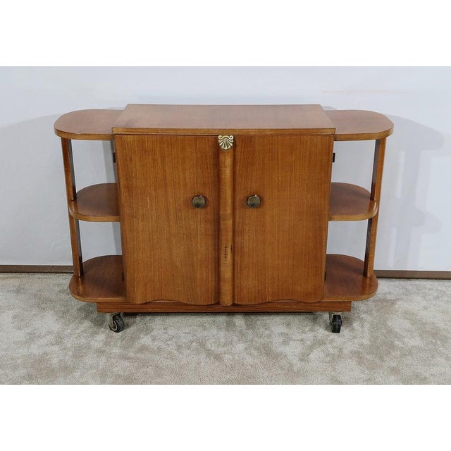 Bar cabinet on casters, made of walnut veneer with sycamore interior. This brightly colored piece has two doors featuring...