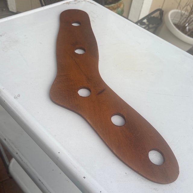 The object is a vintage wooden sock stretcher (also called a sock form or dryer), traditionally used to shape and dry...