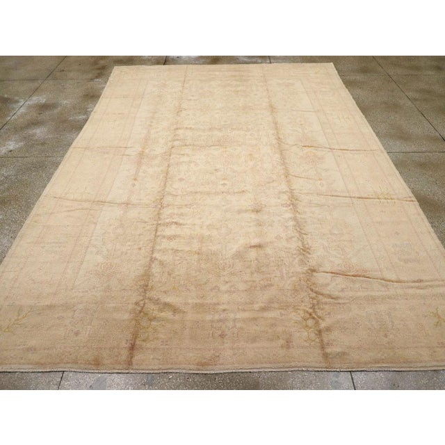 An antique Turkish Oushak carpet. The ambiance is mellow on this west Anatolian workshop carpet with an all-wool...