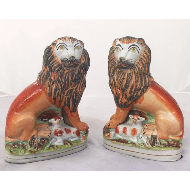 A handsome pair of English Staffordshire pottery decorative animal sculptures, finely modeled and colored as lions with...
