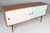 Finn Juhl freestanding credenza in walnut. White and blue sliding doors with shelves behind. Standing on a black painted...