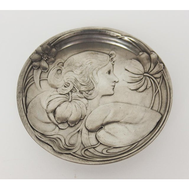 Small Art Nouveau style pewter plate or trinket dish depicting a profile of a young woman surrounded by undulating water...