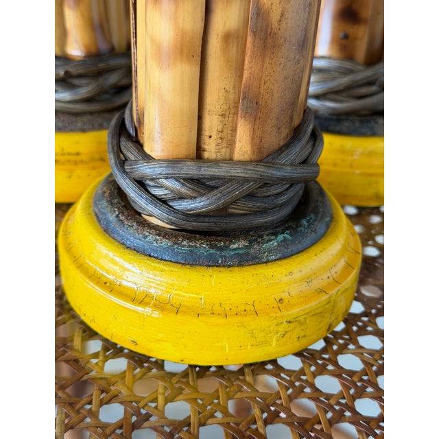 A wonderful set of three vintage bamboo candlesticks featuring natural scorched bamboo, decorative rattan wrappings, and...