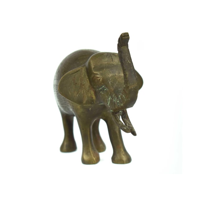 This vintage brass elephant figurine features a joyful, trunk-up pose, traditionally symbolizing good luck, prosperity,...