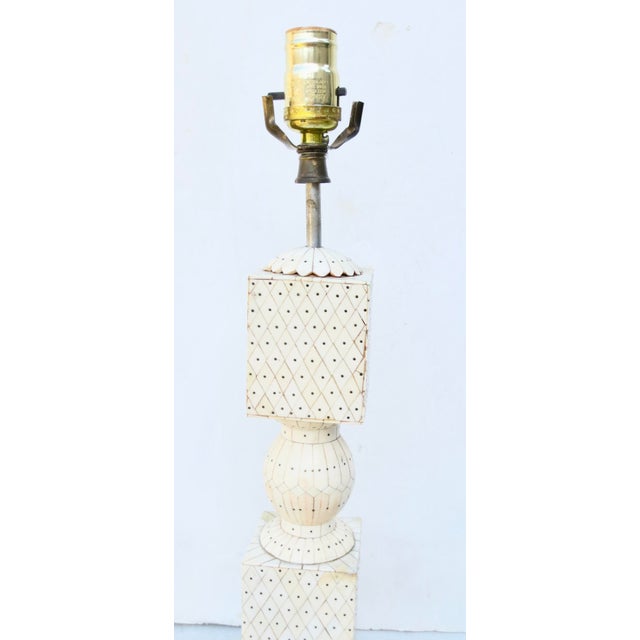From Goa, India, a traditional craft of bone veneer on boxes, furniture, and other items. The lamp has a wooden core to...
