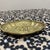 Exhibiting the intricate charm of early to mid-century metalwork, this oval brass dish features a striking repousse...