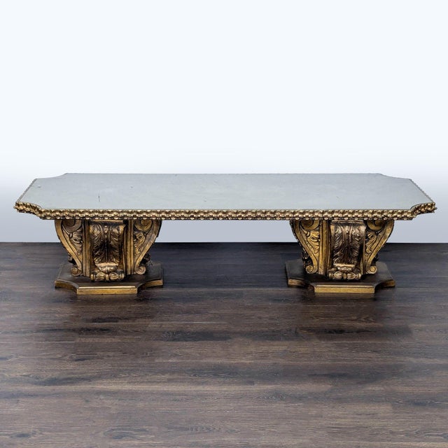 Heavily carved and gilded wood table with a mirrored top. Dimensions (in): 67W x 27D x 16H.