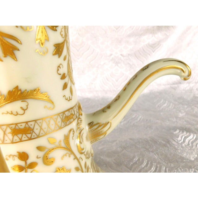 This is a matte white Tressemanes & Vogt Limoges Chocolate Pot with an all over gold painted spout and a raised gold...