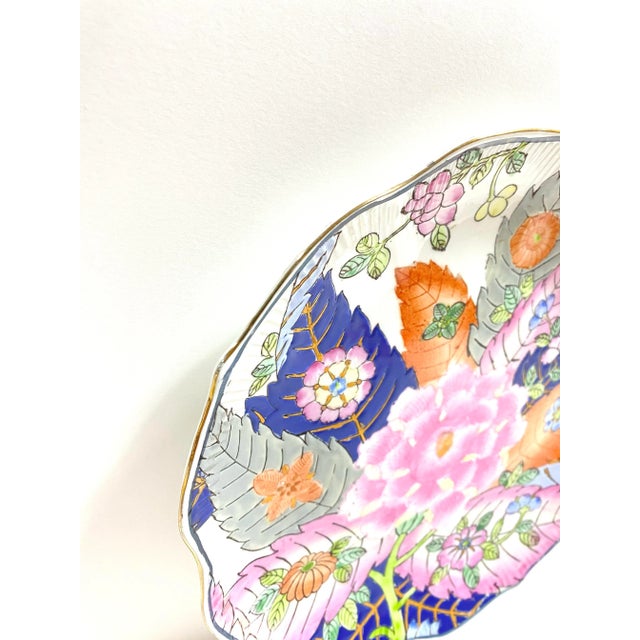 A beautifully decorated Chinese porcelain tobacco leaf plate featuring vibrant enamel colors and intricate floral and...