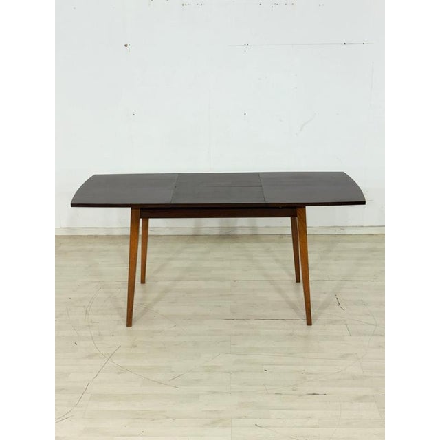 Beautiful, original vintage dining table in a timeless mid-century design. The table impresses with its elegantly shaped,...