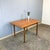 A simple yet elegant dining table with typical 1960s design features – tapered, spindle-shaped legs and the use of teak....