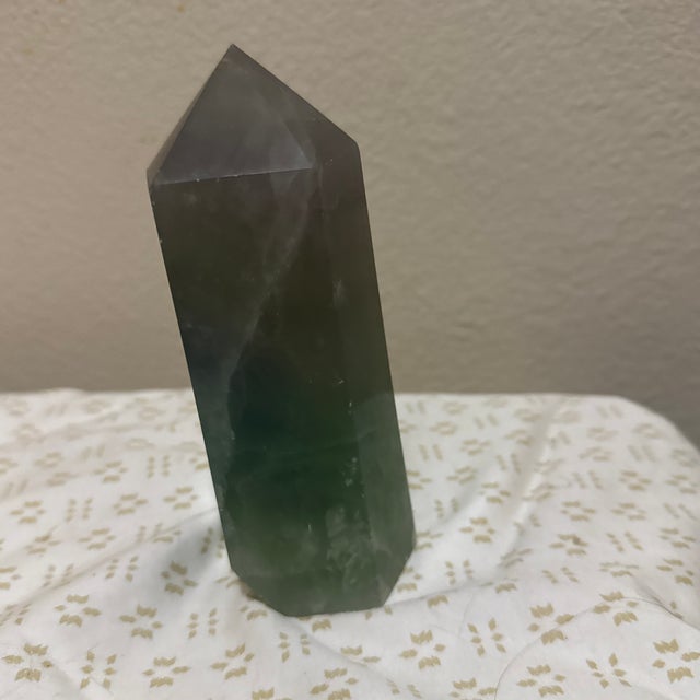 A striking Wide Rainbow Fluorite Obelisk Tower showcasing vibrant bands of purple, green, blue, and clear fluorite. The...