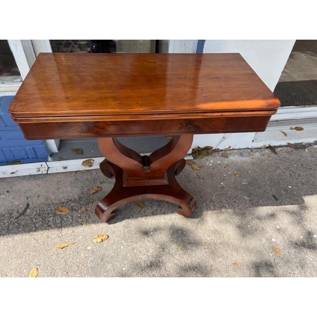 This antique American solid mahogany game card table from the 19th century exudes classic American style. The tabletop and...